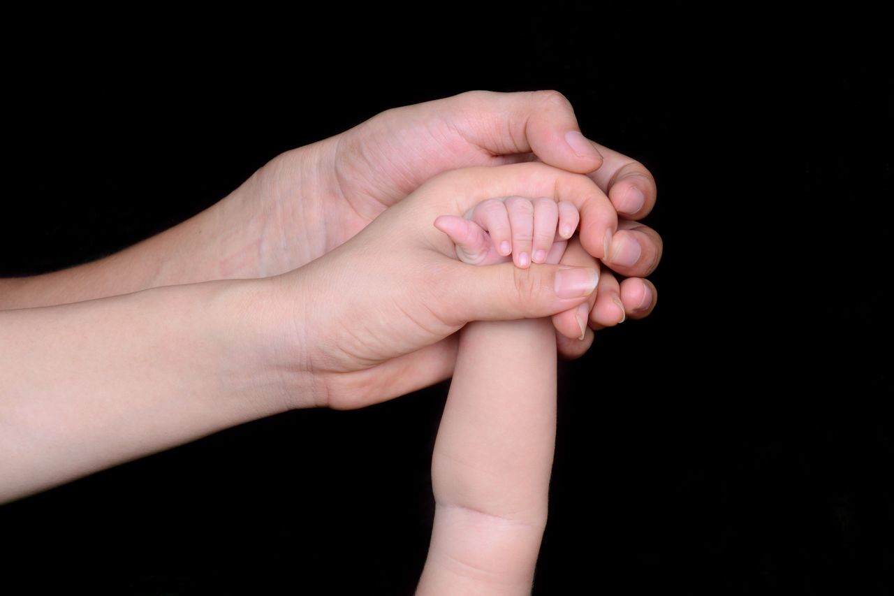 Crafting Captivating Headlines: Your awesome post title goes here A close-up image featuring a baby's hand being held by a parent's hand, symbolizing love and protection.