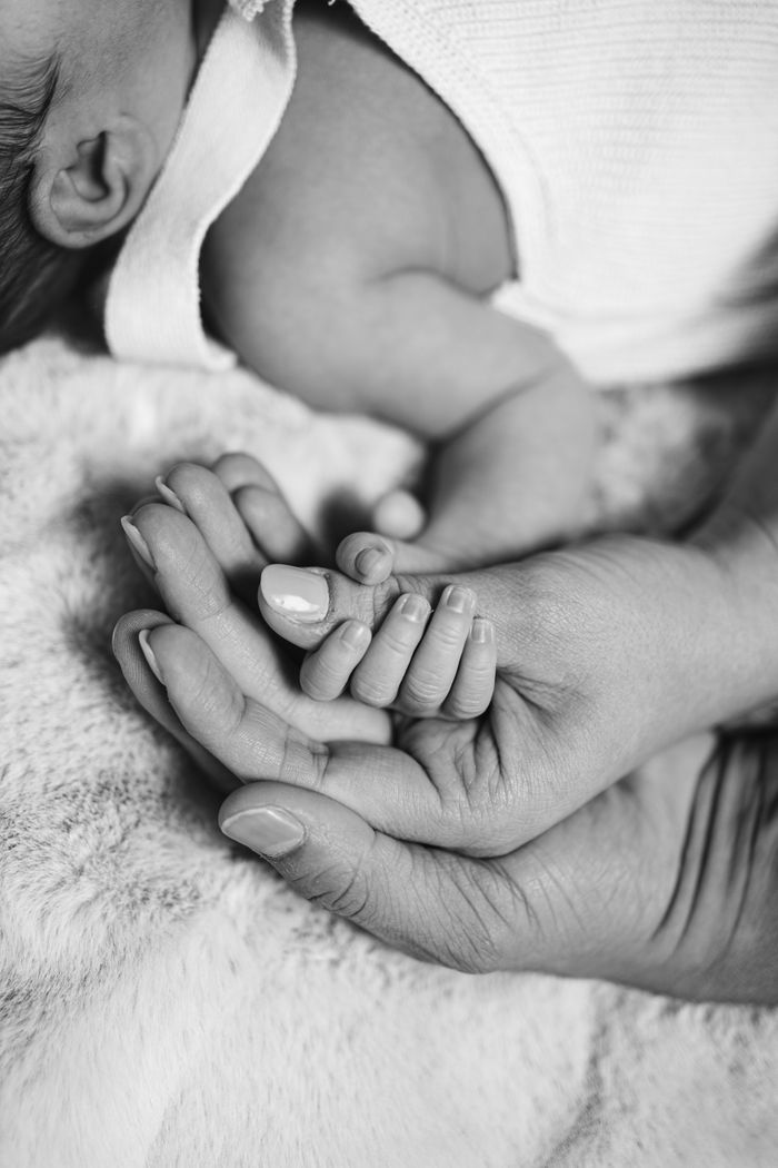 Mastering the First Impression: Your intriguing post title goes here Black and white photo of a newborn baby holding a parent's hand, symbolizing connection and love.